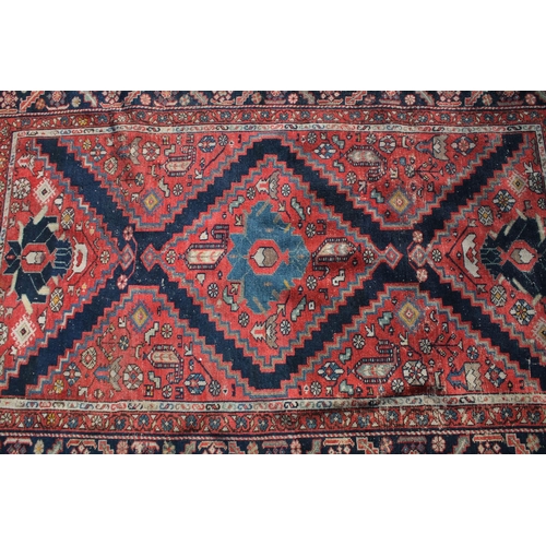 669 - Middle Eastern red ground rug, with central medallion and two half medallions, 197cm x 132cm