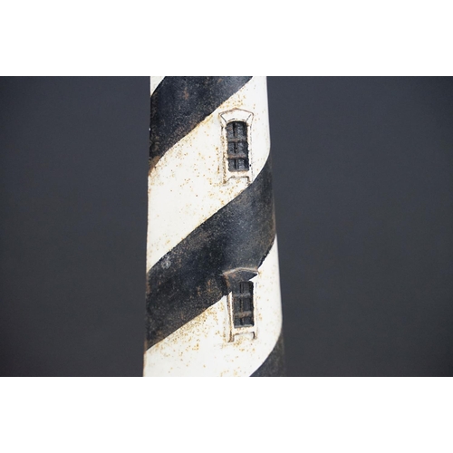 103 - Cast iron doorstop in the form of a lighthouse, with a semi circular base and spiral painted black &... 