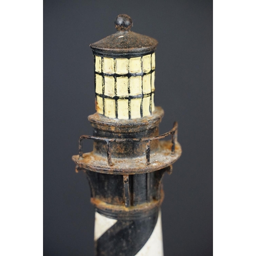 103 - Cast iron doorstop in the form of a lighthouse, with a semi circular base and spiral painted black &... 