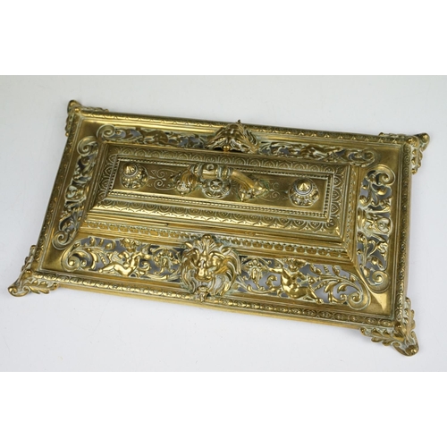 106 - Cast brass inkstand with ornate scrolling and lion mask detail, with hinged cover, approx 35cm wide