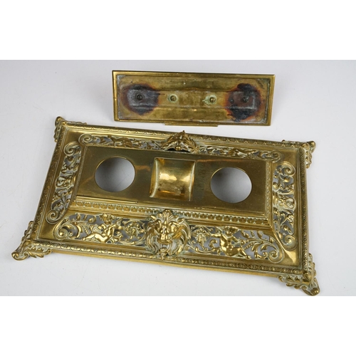 106 - Cast brass inkstand with ornate scrolling and lion mask detail, with hinged cover, approx 35cm wide