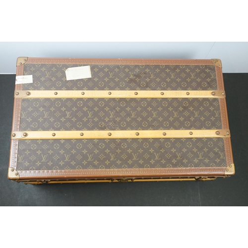 266 - Louis Vuitton - Monogrammed canvas travel trunk having branded leather banding, wooden slats, brass ... 