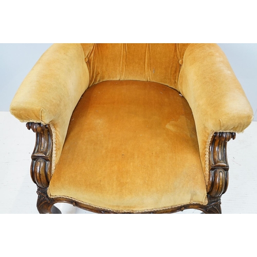 654 - Early 20th century wing back armchair of curved form, with button back, upholstered in orange, on tu... 