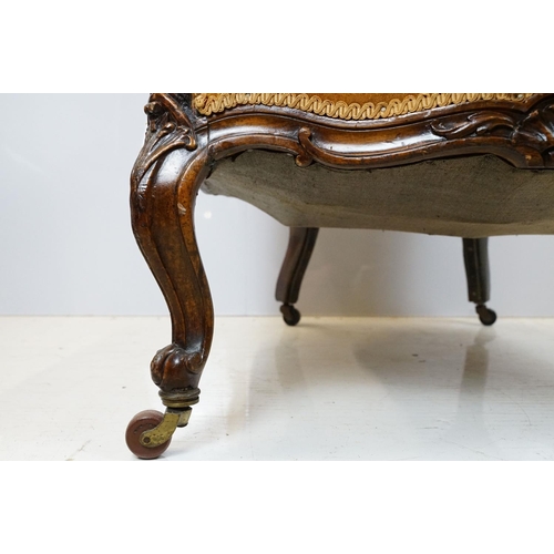 654 - Early 20th century wing back armchair of curved form, with button back, upholstered in orange, on tu... 