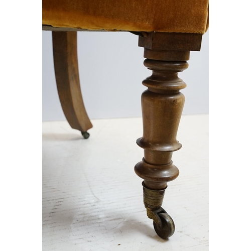 654 - Early 20th century wing back armchair of curved form, with button back, upholstered in orange, on tu... 