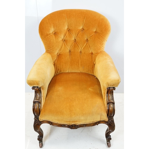 654 - Early 20th century wing back armchair of curved form, with button back, upholstered in orange, on tu... 