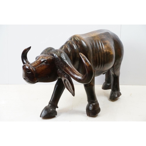 659 - Hardwood carved figure of a water buffalo, 57cm high x 109cm long x 33cm deep