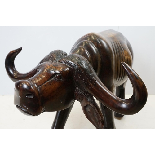 659 - Hardwood carved figure of a water buffalo, 57cm high x 109cm long x 33cm deep