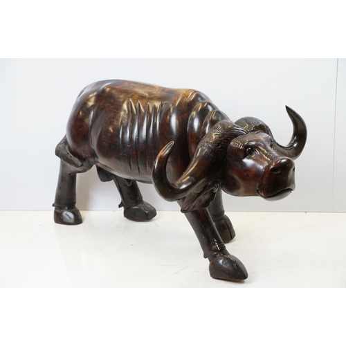 659 - Hardwood carved figure of a water buffalo, 57cm high x 109cm long x 33cm deep