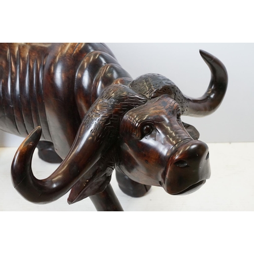 659 - Hardwood carved figure of a water buffalo, 57cm high x 109cm long x 33cm deep