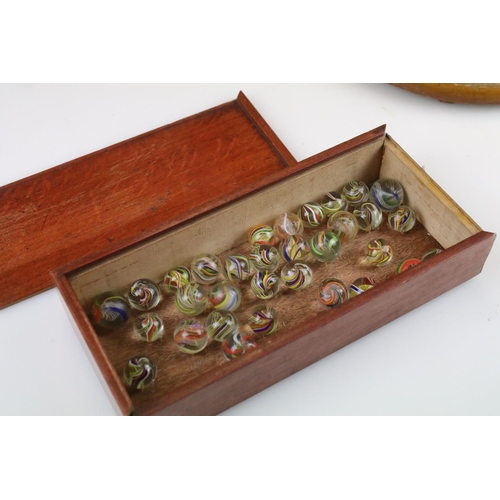 234 - An antique carved wooden solitaire board complete with antique marbles.