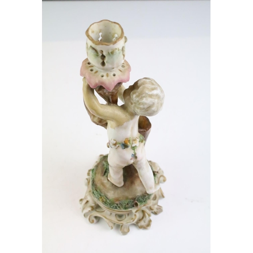 12 - Pair of 19th century Continental porcelain candlesticks modelled with putti, with blue crossed sword... 