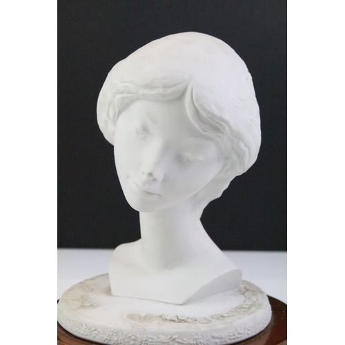 28 - Lladro ceramic bust of a girl raised on a wooden base. Mark to base. Measures 23cm tall.