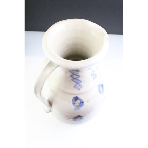 64 - Two pottery jugs with underglaze blue repeating decoration and single handles, tallestapprox 36cm