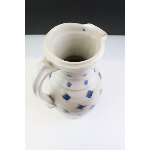 64 - Two pottery jugs with underglaze blue repeating decoration and single handles, tallestapprox 36cm