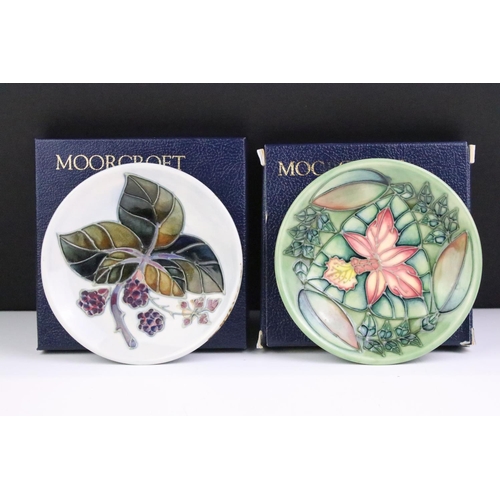 86 - Two boxed Moorcroft pottery pin dishes to include a Bramble Pattern and green ground floral example,... 