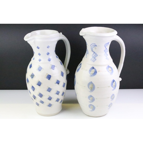 64 - Two pottery jugs with underglaze blue repeating decoration and single handles, tallestapprox 36cm