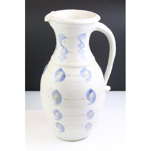 64 - Two pottery jugs with underglaze blue repeating decoration and single handles, tallestapprox 36cm