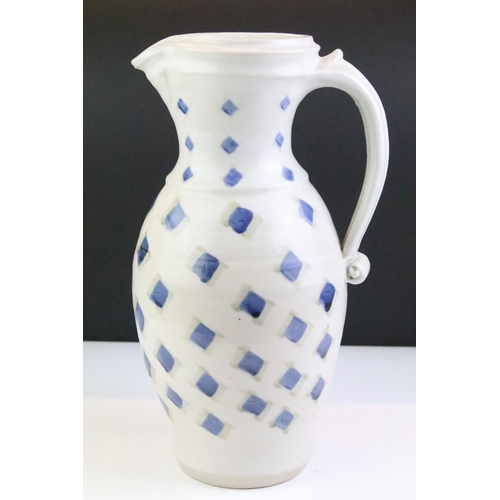 64 - Two pottery jugs with underglaze blue repeating decoration and single handles, tallestapprox 36cm