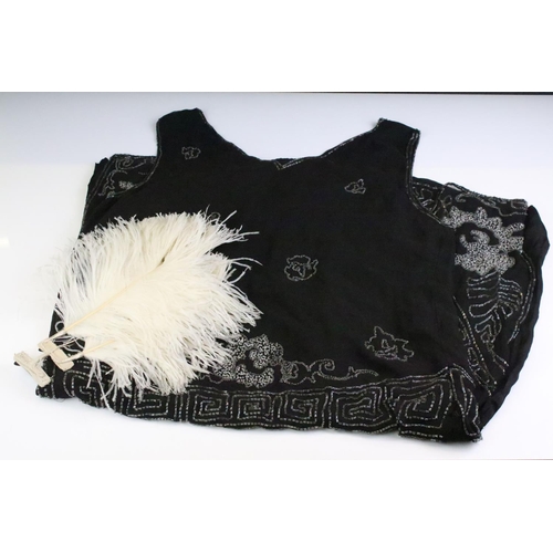 79 - 1920's silk lined black beadwork dress with Greek key style design, together with feather hair decor... 