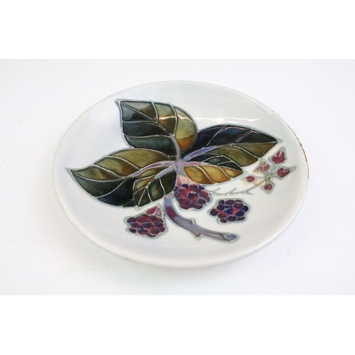 86 - Two boxed Moorcroft pottery pin dishes to include a Bramble Pattern and green ground floral example,... 