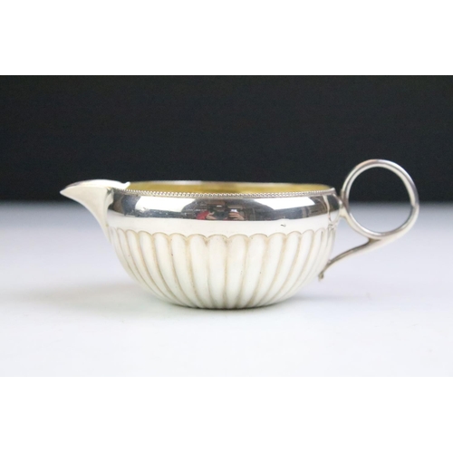 109 - Edwardian Mappin & Webb cased silver cream jug, sugar bowl & sugar tongs set, the sugar bowl and cre... 