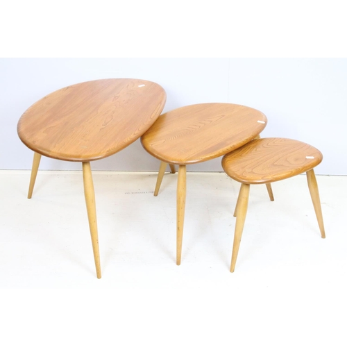 705 - Ercol elm pebble nest of tables each having oval tops raised on tapering turned legs. Ercol sticker ... 