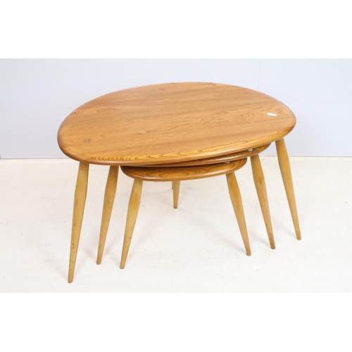 705 - Ercol elm pebble nest of tables each having oval tops raised on tapering turned legs. Ercol sticker ... 