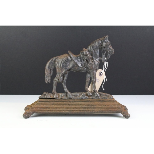 213 - 19th Century Victorian cast iron door stop in the form of a Boer War horse raised on a stepped base.... 