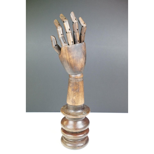 168 - Artist model hand with articulated fingers, raised on a turned wooden base, approx 44cm high