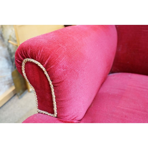 694 - 20th Century red velvet wing backed arm chair raised on tapering oak legs. Measures 102 x 82cm.