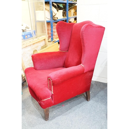 694 - 20th Century red velvet wing backed arm chair raised on tapering oak legs. Measures 102 x 82cm.