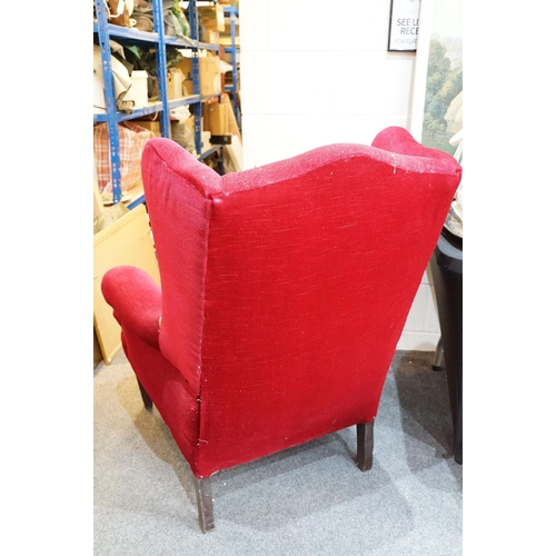 694 - 20th Century red velvet wing backed arm chair raised on tapering oak legs. Measures 102 x 82cm.