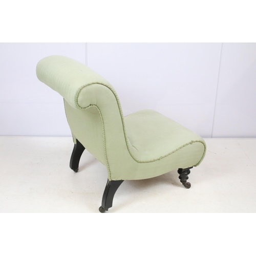 649 - Edwardian nursing chair, with scroll back, upholstered in green on turned tapering legs and castors,... 