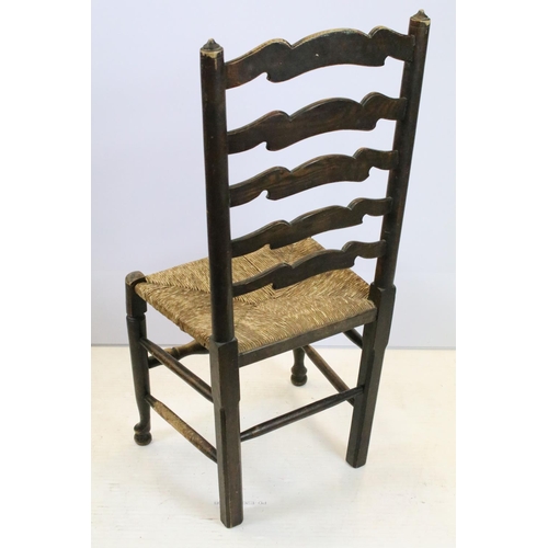 654 - Set of five oak ladder back chairs, including one chair with arms, all with rush seats