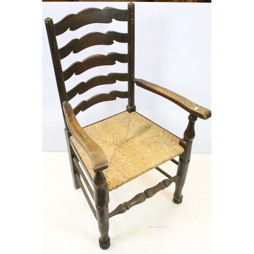 654 - Set of five oak ladder back chairs, including one chair with arms, all with rush seats