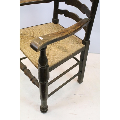 654 - Set of five oak ladder back chairs, including one chair with arms, all with rush seats