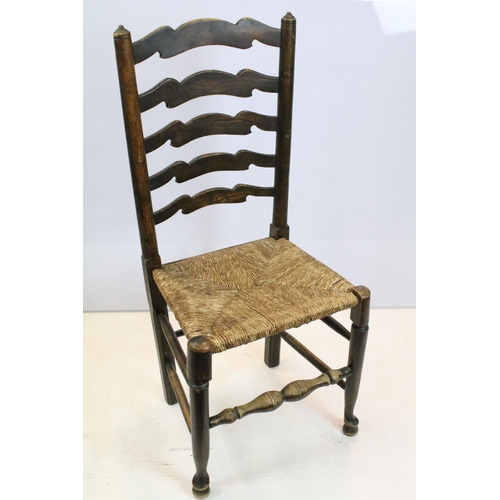 654 - Set of five oak ladder back chairs, including one chair with arms, all with rush seats