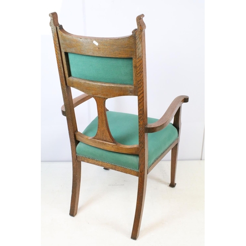 655 - Art Nouveau carved oak open armchair, with ornately carved back, upholstered in green, on tapering l... 