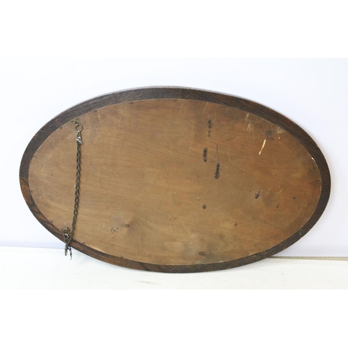 676 - Carved oak oval mirror with bevelled plate, 77 x 49cm