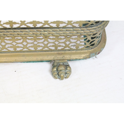 681 - Early 20th century pierced brass fire fender, with three lion's paw feet, 23.5cm high x 129cm wide x... 