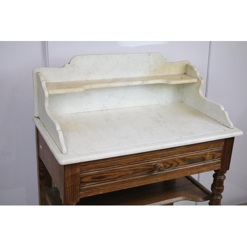 688 - 20th century pine washstand, the marble top with shelf above, with one drawer above turned legs and ... 