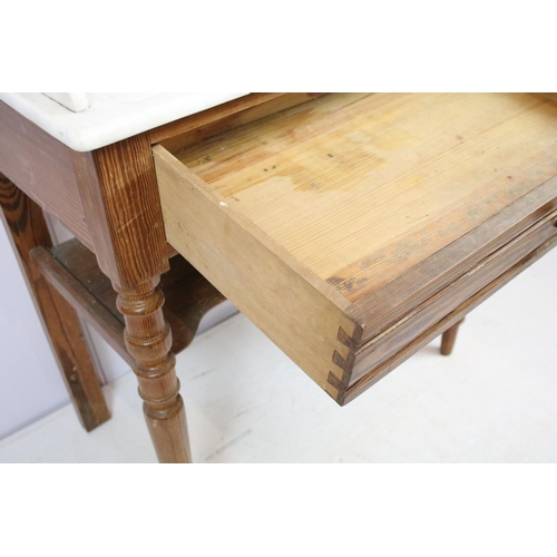 688 - 20th century pine washstand, the marble top with shelf above, with one drawer above turned legs and ... 