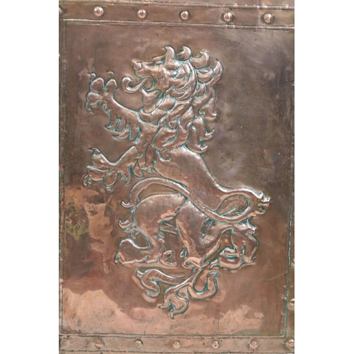 697 - Early 20th century fire screen, the embossed copper panel decorated with a lion rampant, with oak su... 