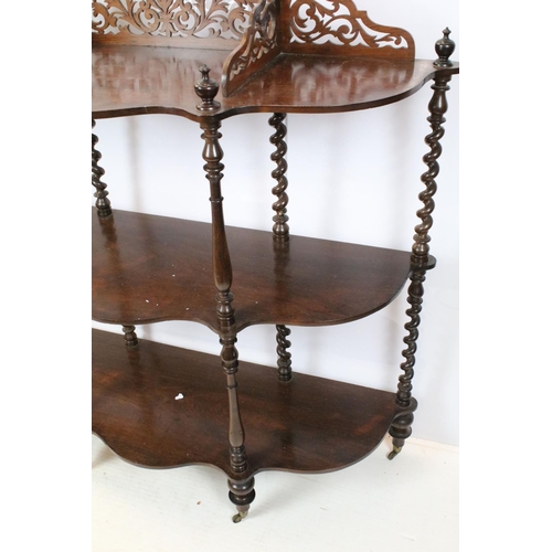 761 - Early 20th century rosewood carved three tier shelf, with raised fretwork galleried back above spira... 