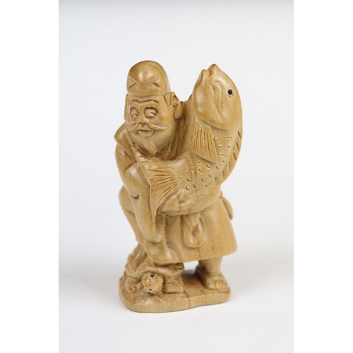 289 - Two Chinese carved wooden netsuke to include a figure of an oriental man holding fish.