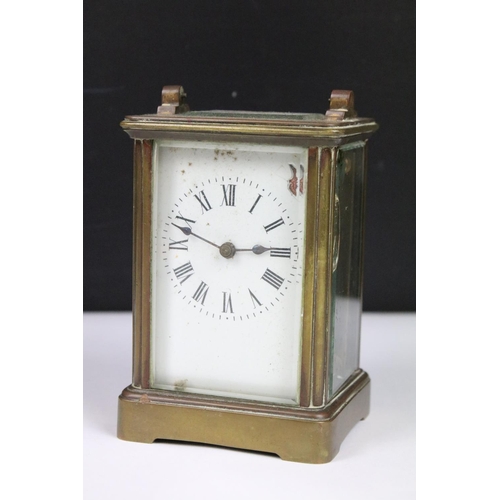 303 - Two vintage brass cased carriage clocks with beveled glass panels and white enamel dials.