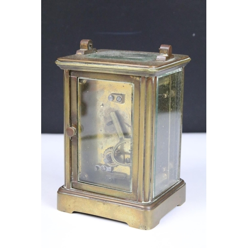 303 - Two vintage brass cased carriage clocks with beveled glass panels and white enamel dials.