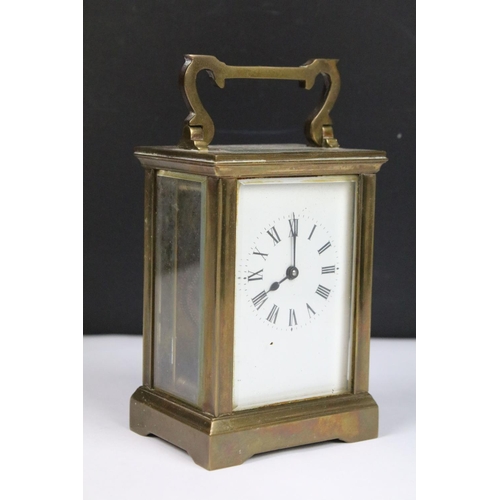 303 - Two vintage brass cased carriage clocks with beveled glass panels and white enamel dials.