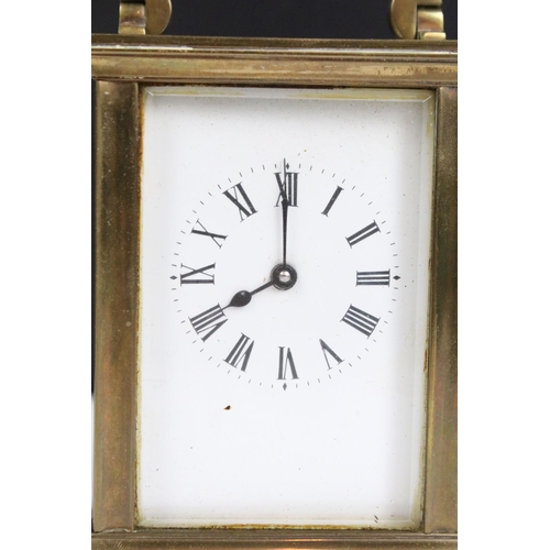 303 - Two vintage brass cased carriage clocks with beveled glass panels and white enamel dials.